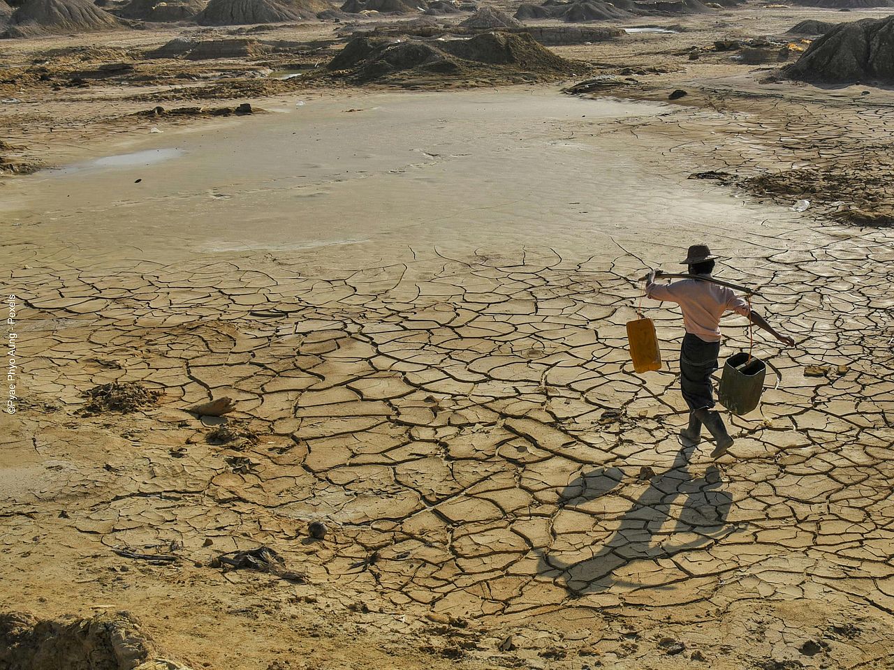 Eine Person läuft über ausgedörrten Boden.  Eine Person läuft über ausgedörrten Boden.