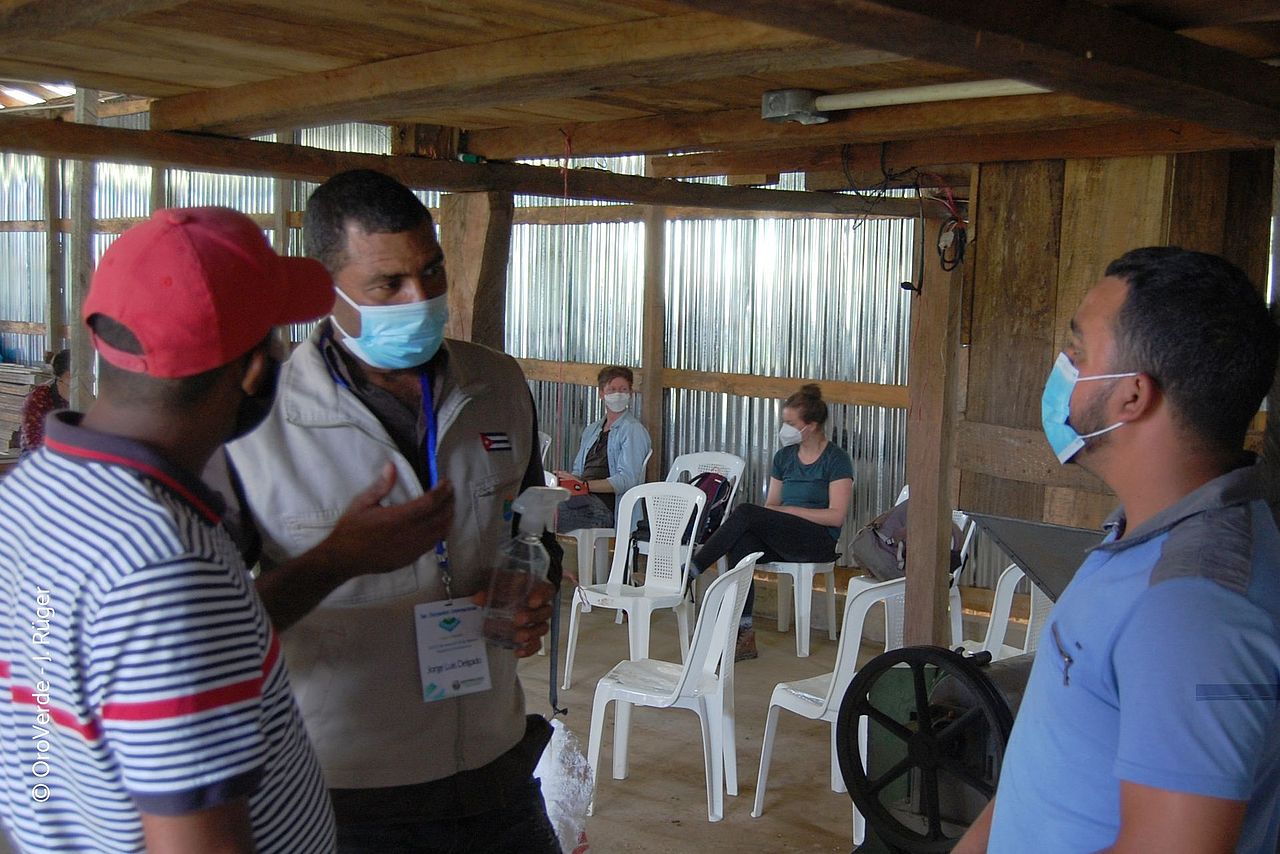 Jorge Luis Delgado, Agrartechniker bei WasserWald Kuba, im Gespräch mit Mitgliedern einer dominikanischen Kaffee-Kooperative. © OroVerde - J.Rüger